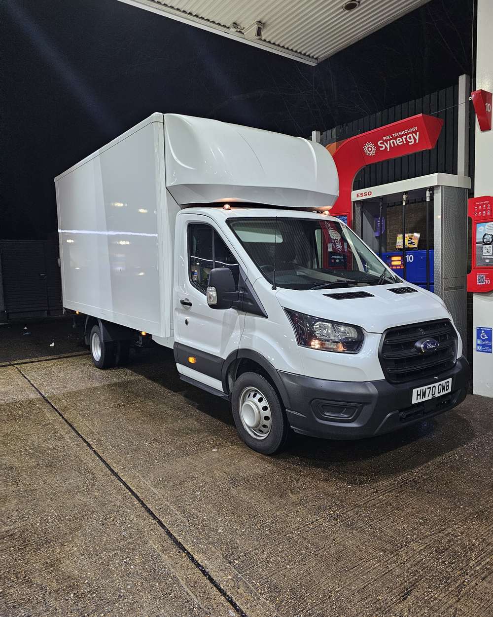 White Ford Transit Luton van with tail-lift at night